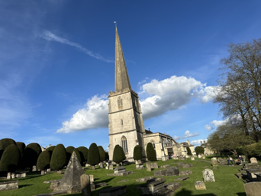 An old church with a graveyard in a field.