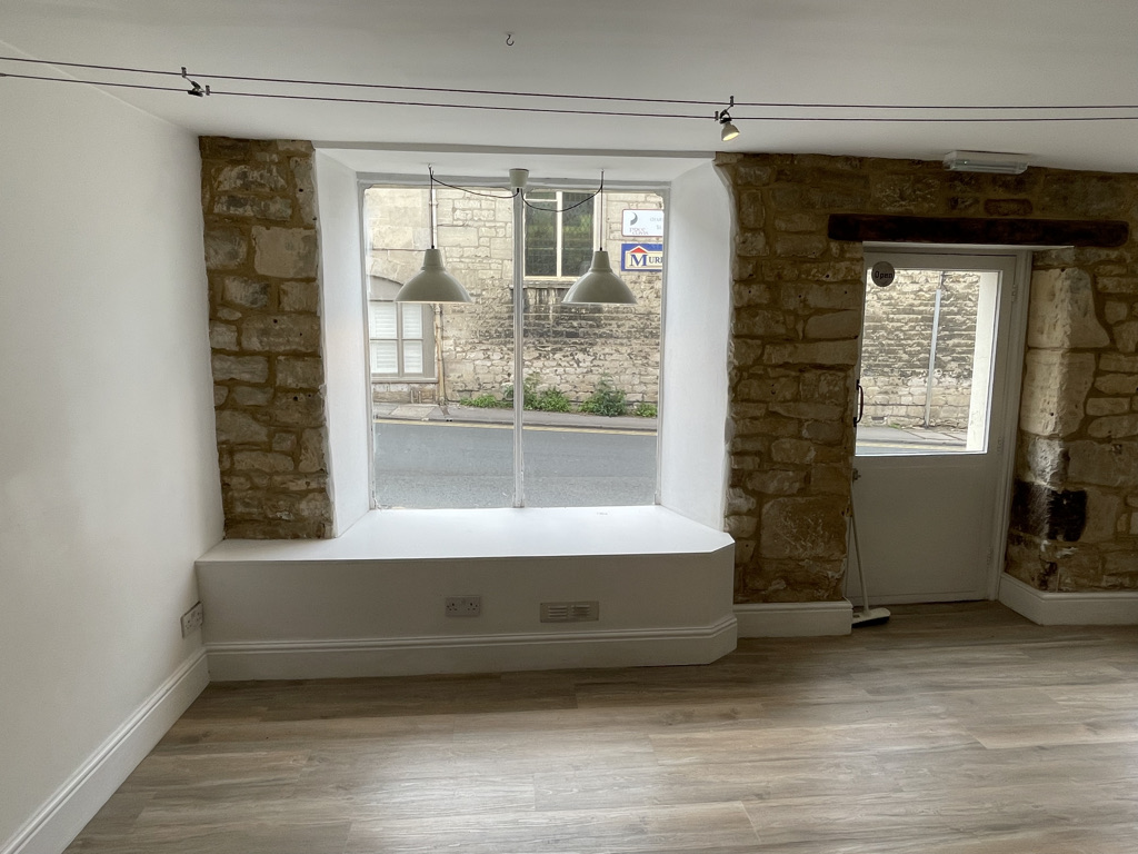 Interiors of a commercial space, which has gone out of business. The photo was taken at ground level in front of a stone w...